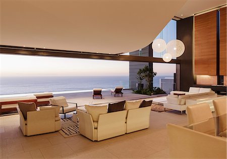 simsearch:6113-07542764,k - Living room in modern house overlooking ocean at sunset Stock Photo - Premium Royalty-Free, Code: 6113-07543347