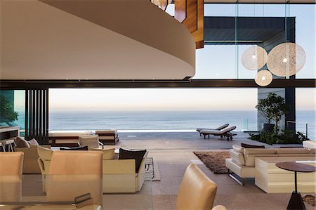 simsearch:6113-07542650,k - Modern living room overlooking ocean at sunset Foto de stock - Sin royalties Premium, Código: 6113-07543361