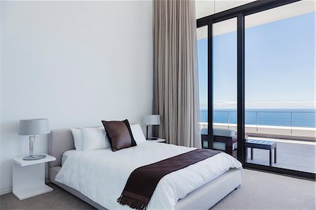 simsearch:6113-07542742,k - Bed and lamps in modern bedroom overlooking ocean Stock Photo - Premium Royalty-Free, Code: 6113-07543364