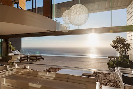 simsearch:6113-07159869,k - Modern living room overlooking ocean at sunset Stock Photo - Premium Royalty-Free, Code: 6113-07543378