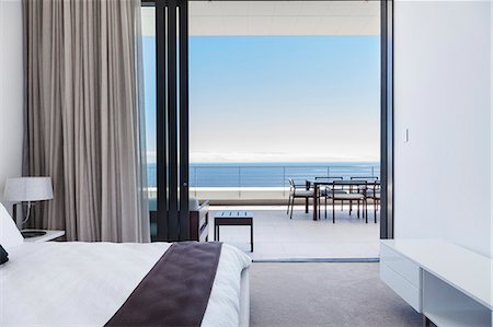 simsearch:6113-07542764,k - Modern bedroom and balcony overlooking ocean Stock Photo - Premium Royalty-Free, Code: 6113-07543309