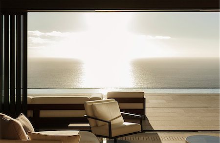 simsearch:6113-07542742,k - Modern living room overlooking ocean at sunset Stock Photo - Premium Royalty-Free, Code: 6113-07543327