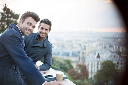 Businessmen smiling at railing overlooking Paris, France Stock Photo - Premium Royalty-Free, Code: 6113-07543450