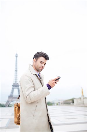 Businessman using cell phone by Eiffel Tower, Paris, France Stock Photo - Premium Royalty-Free, Code: 6113-07543400