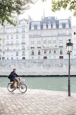 paris street lamps - Man riding bicycle along Seine River, Paris, France Foto de stock - Sin royalties Premium, Código: 6113-07543515