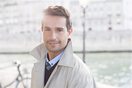 Businessman smiling along Seine River, Paris, France Stock Photo - Premium Royalty-Free, Code: 6113-07543524