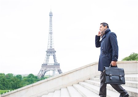 Businessmen on cell phone on steps near Eiffel Tower, Paris, France Foto de stock - Sin royalties Premium, Código: 6113-07543528