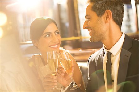 restaurant lifestyle - Well-dressed couple toasting champagne flutes in restaurant Stock Photo - Premium Royalty-Free, Code: 6113-07543628