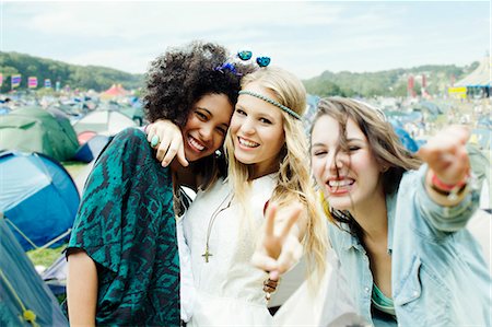 Friends hugging outside tents at music festival Stock Photo - Premium Royalty-Free, Code: 6113-07564752