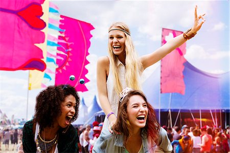 simsearch:6113-06899255,k - Woman piggybacking enthusiastic friend at music festival Stock Photo - Premium Royalty-Free, Code: 6113-07564879