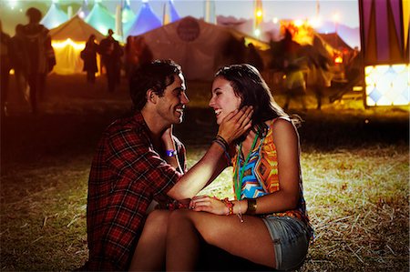 photo of a woman touching a man face - Affectionate couple outside music festival Stock Photo - Premium Royalty-Free, Code: 6113-07564910