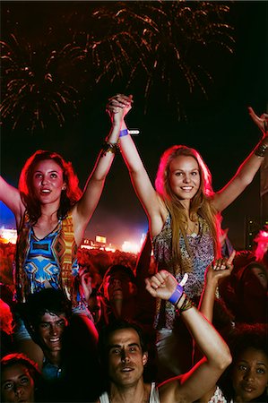 simsearch:6115-08105215,k - Cheering women on men's shoulders at music festival Foto de stock - Sin royalties Premium, Código: 6113-07564928