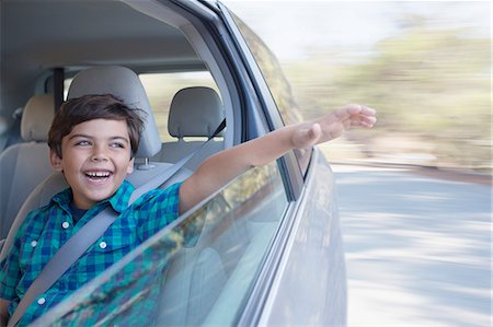 Happy boy sticking hand out window of car Stock Photo - Premium Royalty-Free, Code: 6113-07564937