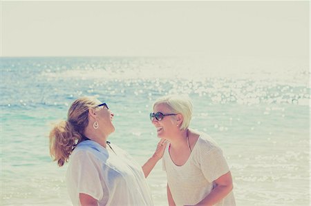 Women laughing on sunny beach Stock Photo - Premium Royalty-Free, Code: 6113-07565157