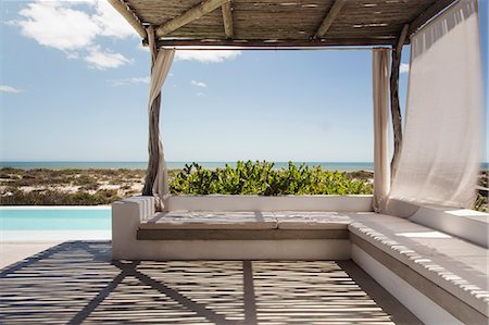 simsearch:6113-07147822,k - Luxury poolside patio overlooking ocean Photographie de stock - Premium Libres de Droits, Code: 6113-07565182