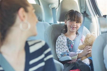 friendship children - Mother turning and smiling at daughter in back seat of car Stock Photo - Premium Royalty-Free, Code: 6113-07565138