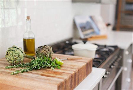 Artichokes, rosemary, olive oil and lime on cutting board Stock Photo - Premium Royalty-Free, Code: 6113-07565257