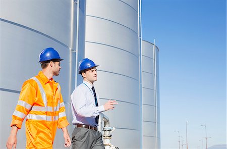 simsearch:6113-07565342,k - Businessman and worker walking near silage storage towers Stock Photo - Premium Royalty-Free, Code: 6113-07565344