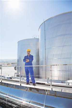 Worker with arms crossed on platform above stainless steel milk tanker Foto de stock - Sin royalties Premium, Código: 6113-07565379