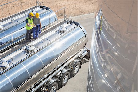 Workers on platform above stainless steel milk tanker Foto de stock - Sin royalties Premium, Código: 6113-07565428