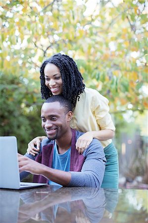 simsearch:6113-06753677,k - Happy couple using laptop at patio table Stock Photo - Premium Royalty-Free, Code: 6113-07565595