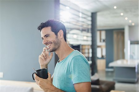 Happy man talking on cell phone and drinking coffee at home Stock Photo - Premium Royalty-Free, Code: 6113-07565687