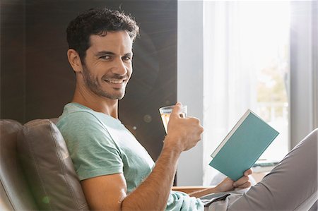 relaxed - Portrait of smiling man drinking tea and reading book Stock Photo - Premium Royalty-Free, Code: 6113-07565695