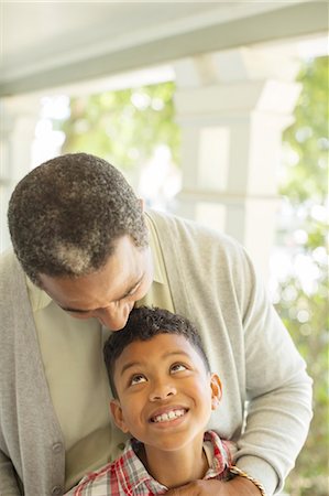 senior man grandchild - Grandfather hugging grandson on porch Stock Photo - Premium Royalty-Free, Code: 6113-07565617