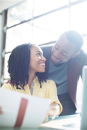 Happy couple with paperwork at laptop Stock Photo - Premium Royalty-Free, Code: 6113-07565616