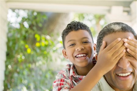 Close up portrait of grandson surprising grandfather Stock Photo - Premium Royalty-Free, Code: 6113-07565620