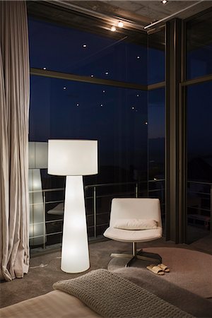 Lamp and chair in corner of modern bedroom Fotografie stock - Premium Royalty-Free, Codice: 6113-07565788