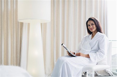 simsearch:6113-07731119,k - Portrait of smiling woman in bathrobe reading newspaper Stock Photo - Premium Royalty-Free, Code: 6113-07565710