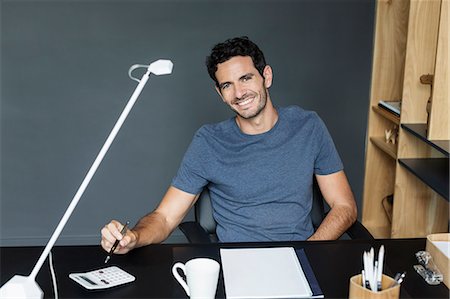Portrait of smiling man at desk in home office Stock Photo - Premium Royalty-Free, Code: 6113-07565734