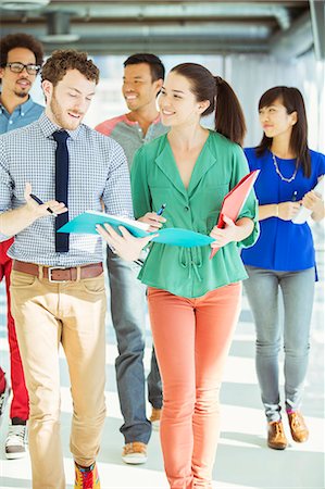 Creative business people with folders walking in office corridor Stock Photo - Premium Royalty-Free, Code: 6113-07565892