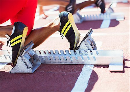 running track competition - Runner's feet in starting blocks on track Stock Photo - Premium Royalty-Free, Code: 6113-07588650