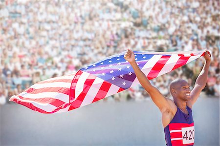 Track and field athlete holding American flag in stadium Stock Photo - Premium Royalty-Free, Code: 6113-07588661