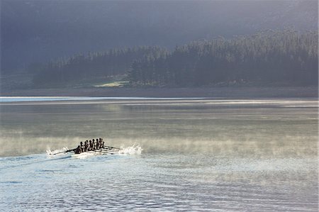 simsearch:6113-07588752,k - Rowing crew rowing scull on lake Photographie de stock - Premium Libres de Droits, Code: 6113-07588796