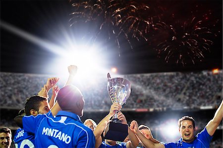 soccer stadium at nights - Soccer team celebrating with trophy on field Stock Photo - Premium Royalty-Free, Code: 6113-07588863