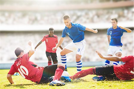 simsearch:6113-07588693,k - Soccer players sliding on field Stock Photo - Premium Royalty-Free, Code: 6113-07588880