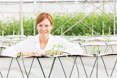 simsearch:6113-07589172,k - Portrait of smiling scientist with plants in greenhouse Stock Photo - Premium Royalty-Free, Code: 6113-07589145