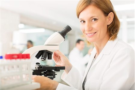 Portrait of confident scientist using microscope in laboratory Stock Photo - Premium Royalty-Free, Code: 6113-07589199