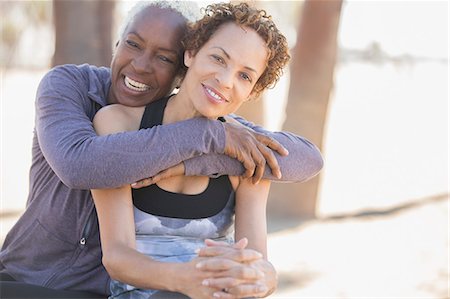 Smiling women hugging outdoors Stock Photo - Premium Royalty-Free, Code: 6113-07589415