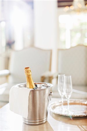 Champagne in silver bucket next to champagne flutes Photographie de stock - Premium Libres de Droits, Code: 6113-07589595