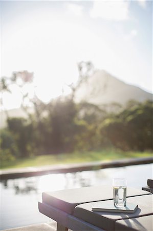 swimmingpool without people - Water glass and book on lounge chair at sunny poolside Stock Photo - Premium Royalty-Free, Code: 6113-07589764