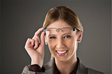 remove - Portrait of confident businesswoman raising eyeglasses Stock Photo - Premium Royalty-Free, Code: 6113-07648743