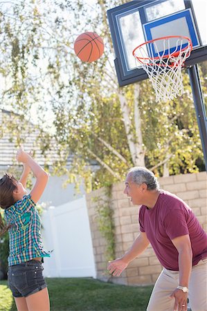 Grandfather and granddaughter playing basketball Stock Photo - Premium Royalty-Free, Code: 6113-07648775