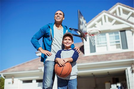 father son basketball - Father and son with basketball in driveway Stock Photo - Premium Royalty-Free, Code: 6113-07648798