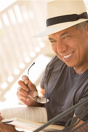 photo of person sitting on porch - Portrait of smiling man reading book Stock Photo - Premium Royalty-Free, Code: 6113-07648884