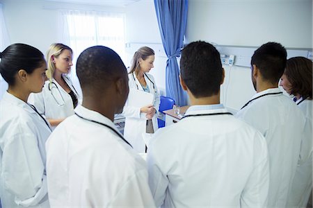 doctor standing talking to patient - Doctor and residents examining patient in hospital room Stock Photo - Premium Royalty-Free, Code: 6113-07761950