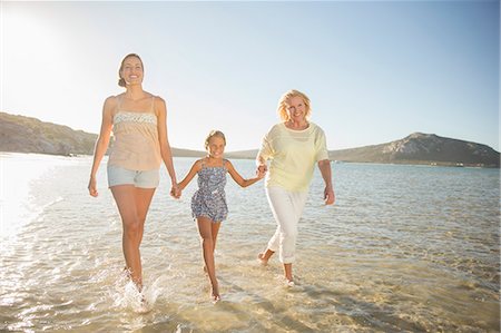 simsearch:6113-08393683,k - Three generations of women walking in waves Stock Photo - Premium Royalty-Free, Code: 6113-07762169